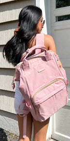 Mochila Rosa de abertura ampla em uso nas costas, recorte da foto correspondente ao modelo
