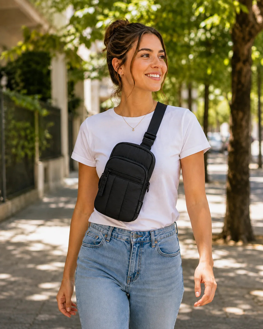 Mulher usando pochete transversal preta Bags Mart em caminhada urbana